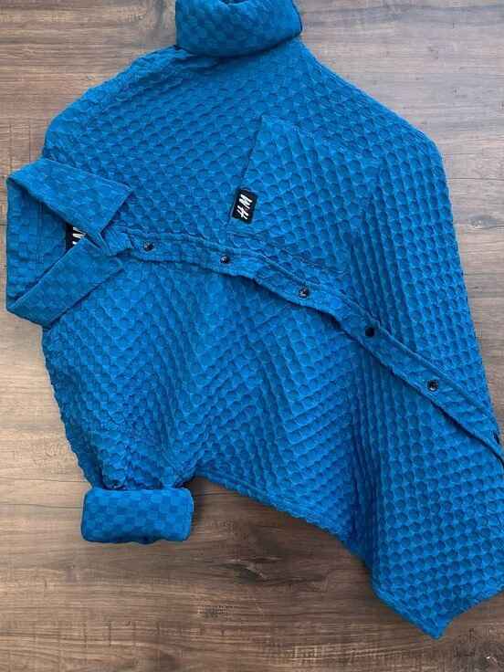 The shirt has a high, turtle-neck-like collar
